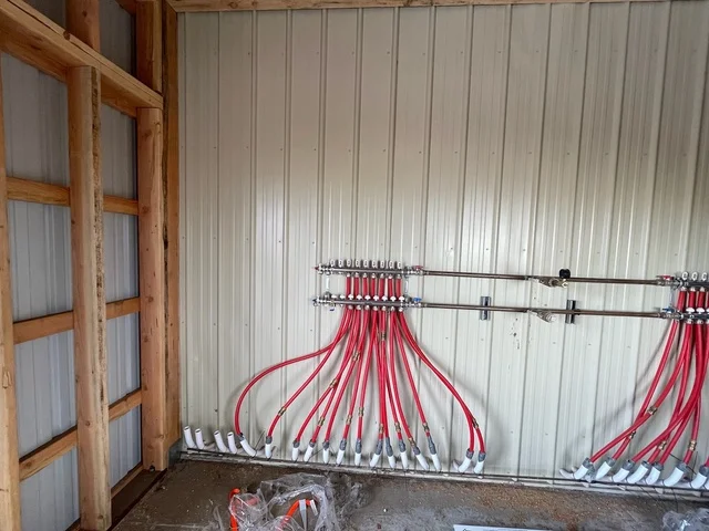 Red insulated flex ducts and metal ductwork mounted on ceiling in industrial space