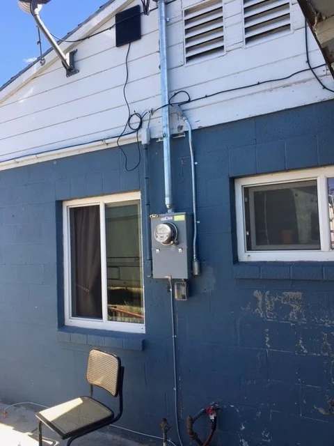 RV exterior showing installed HVAC unit with ducting and electrical connections on blue siding
