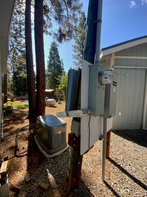 Heat pump condenser units installed on gravel pad with refrigerant lines and electrical connections