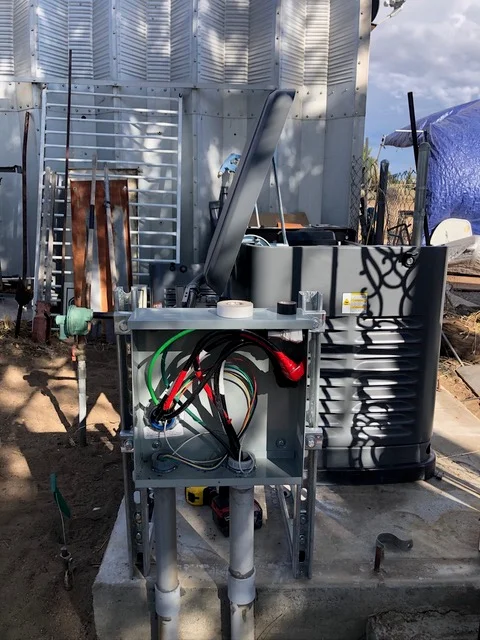 Metal HVAC equipment platform with ductwork and storage tank installed at agricultural grain silo facility