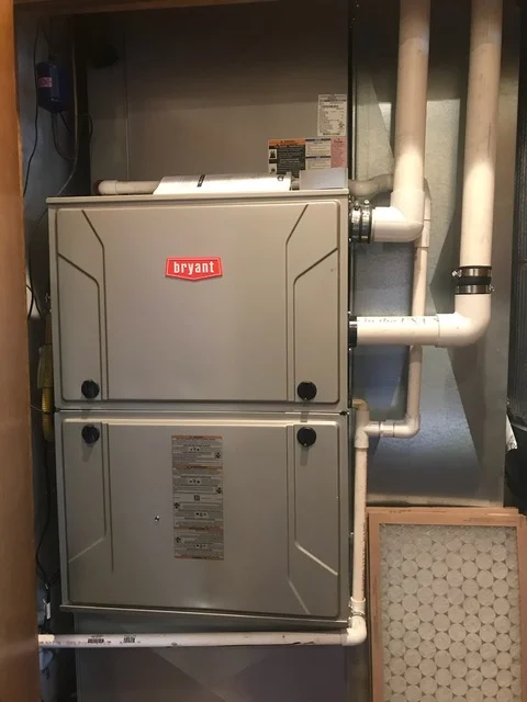 Bryant furnace installation with white PVC ductwork and copper piping connections